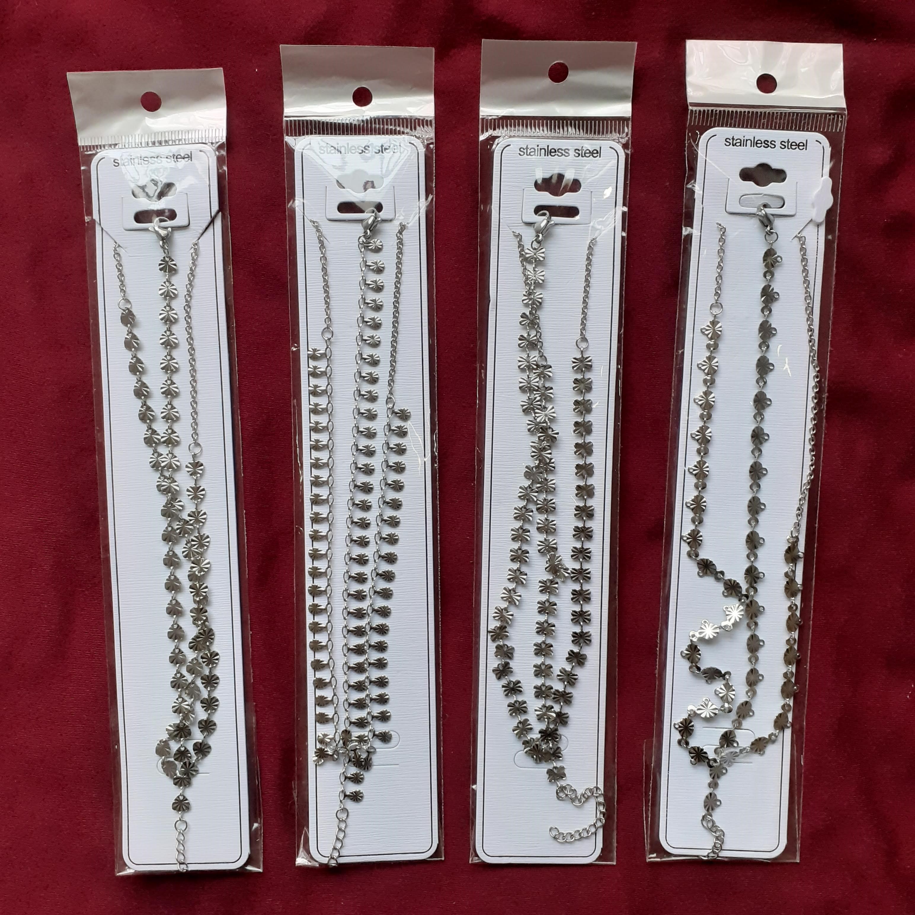 12 juegos de pulsera (23 cm) y collar (58 cm) plateados de acero inoxidable (varios modelos)